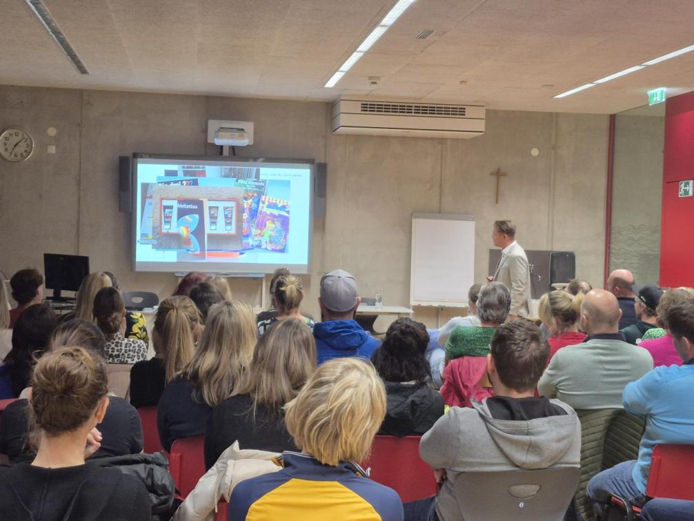 Bild zeigt Vortragenden mit zahlreichen Zuschauerinnen und Zuschauern